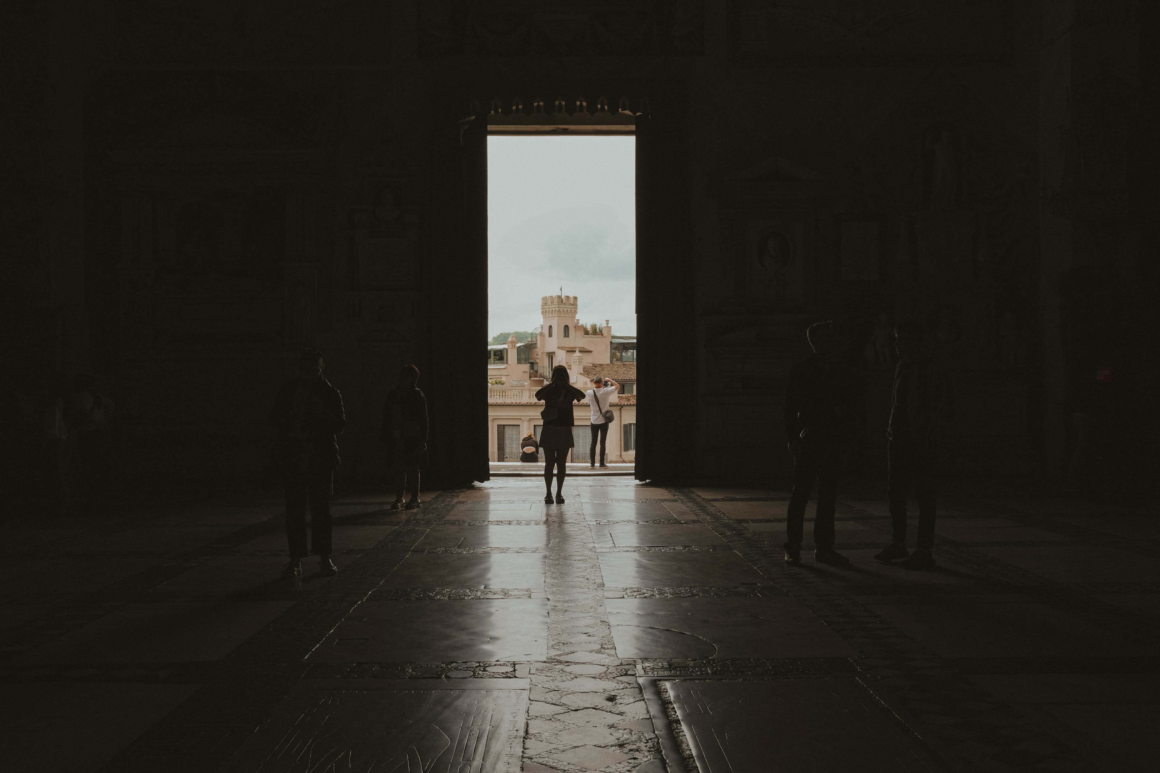 Silhouette of someone taking a photo inside a dark church