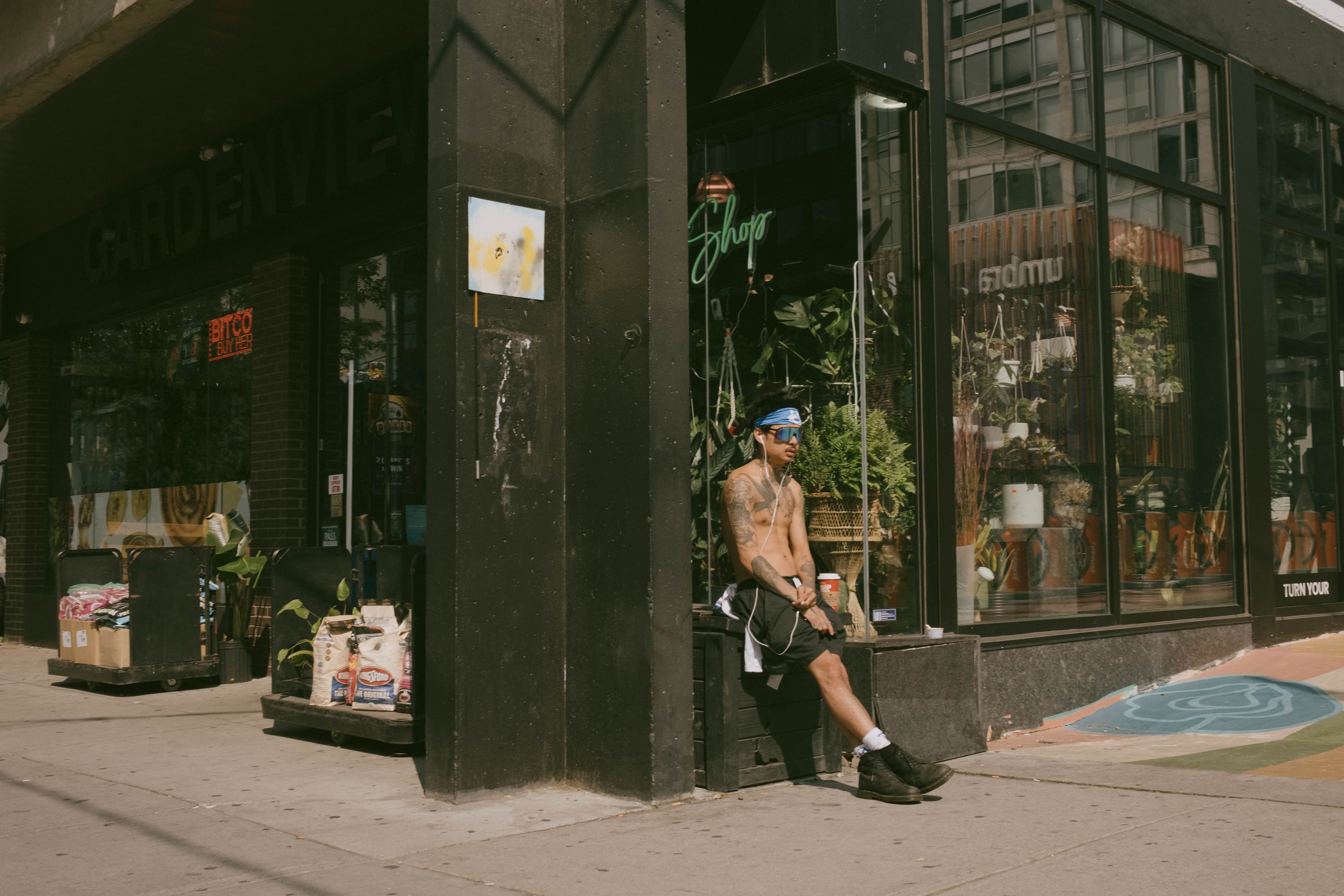 A man resting at a storefront after running