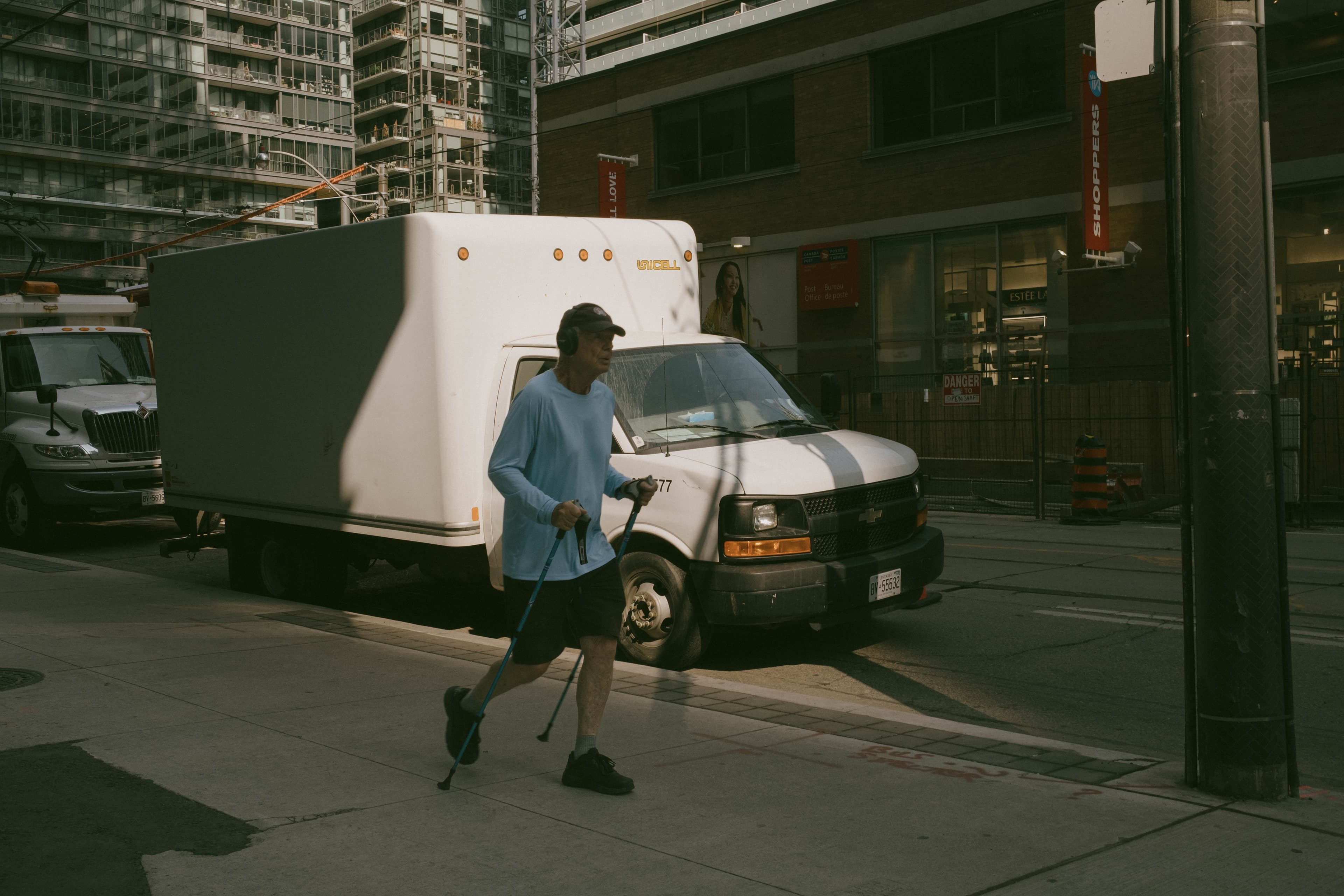 A man walking on a city street with hiking poles