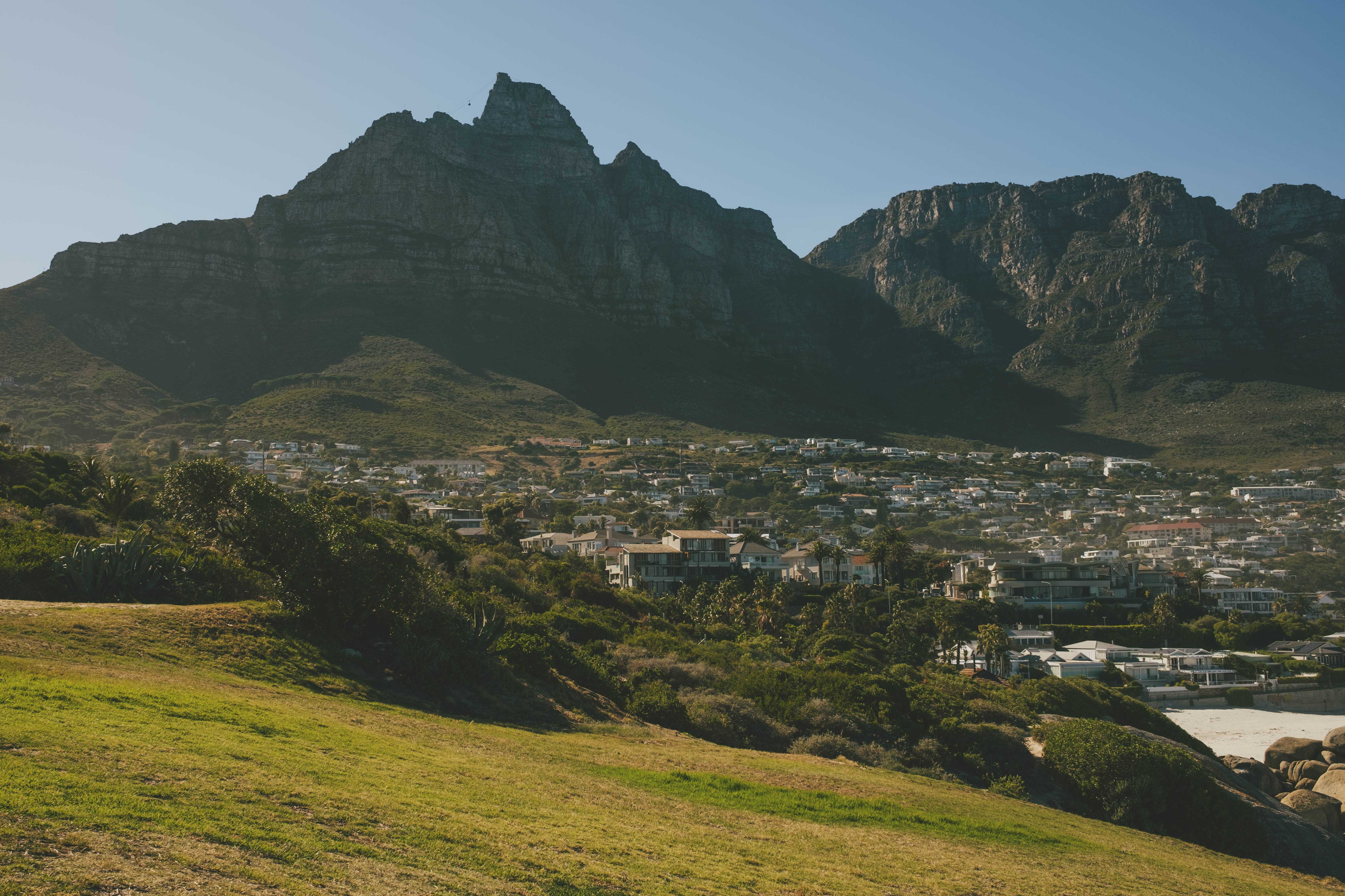 Camps Bay Bay with Table Mountain in the background casting a large shadow.