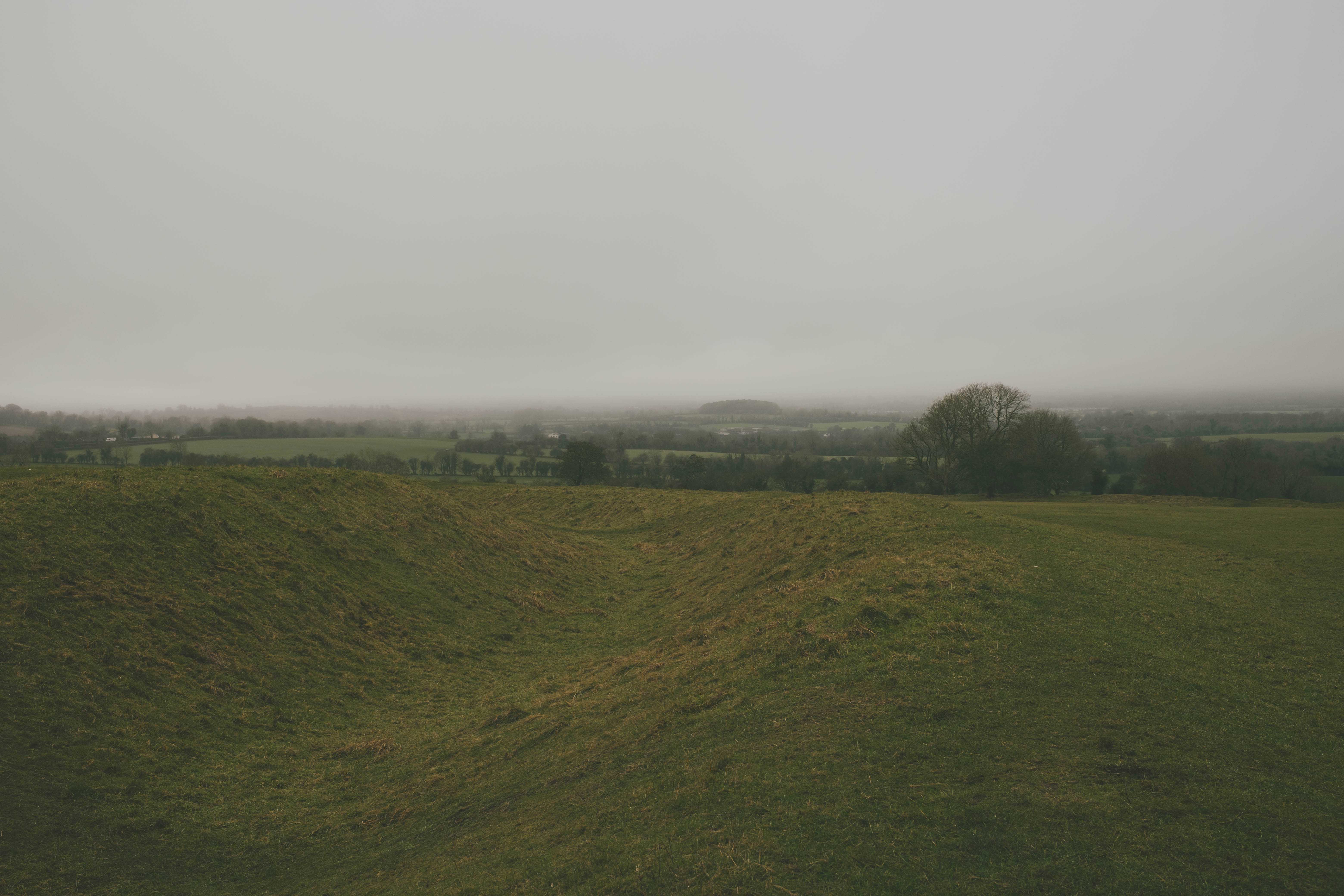 Recess in the mounds of the Hill of Tara, looking over the countryside on a cloudy, misty day