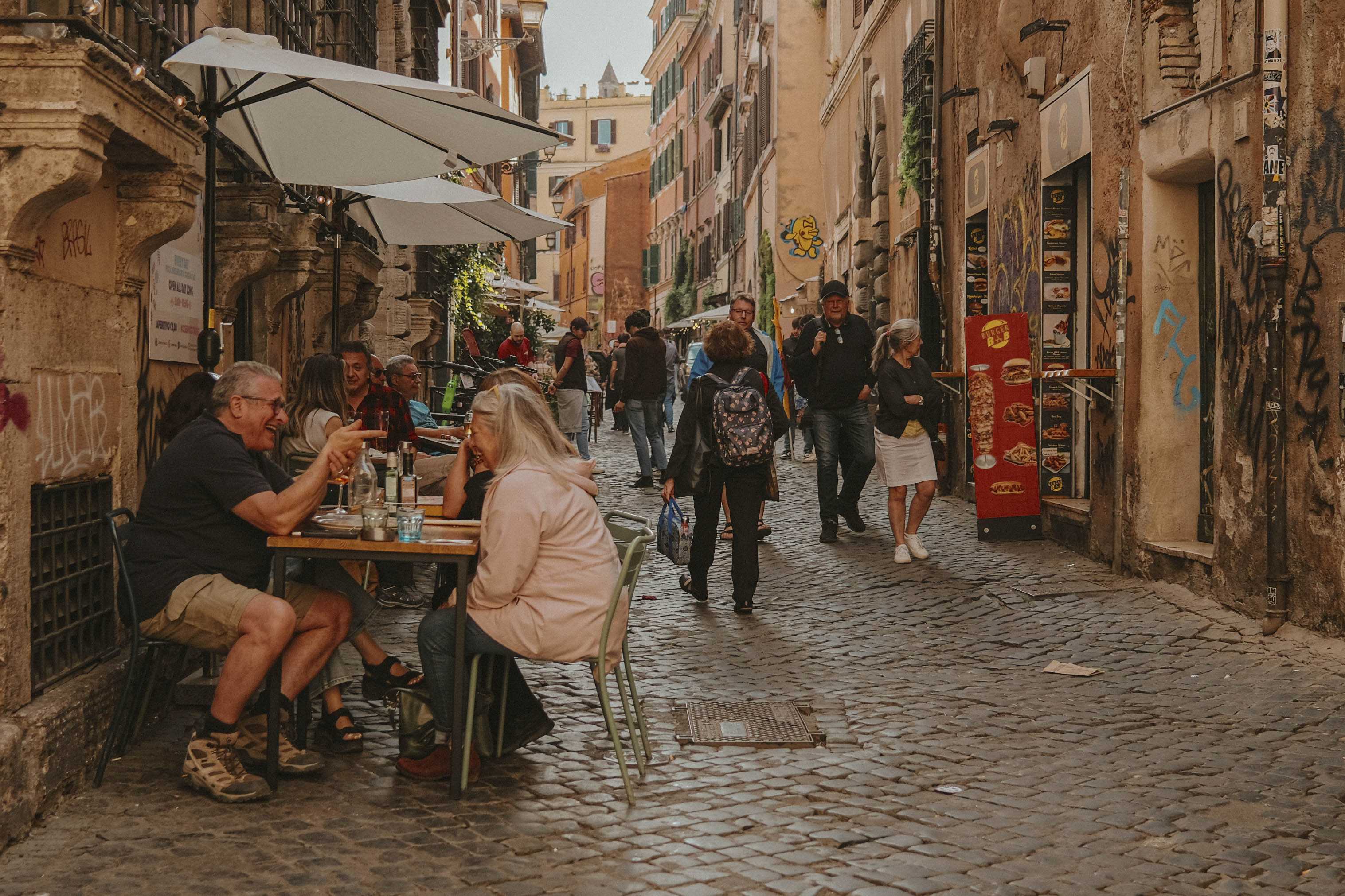 Crowded street with people dining al fresco