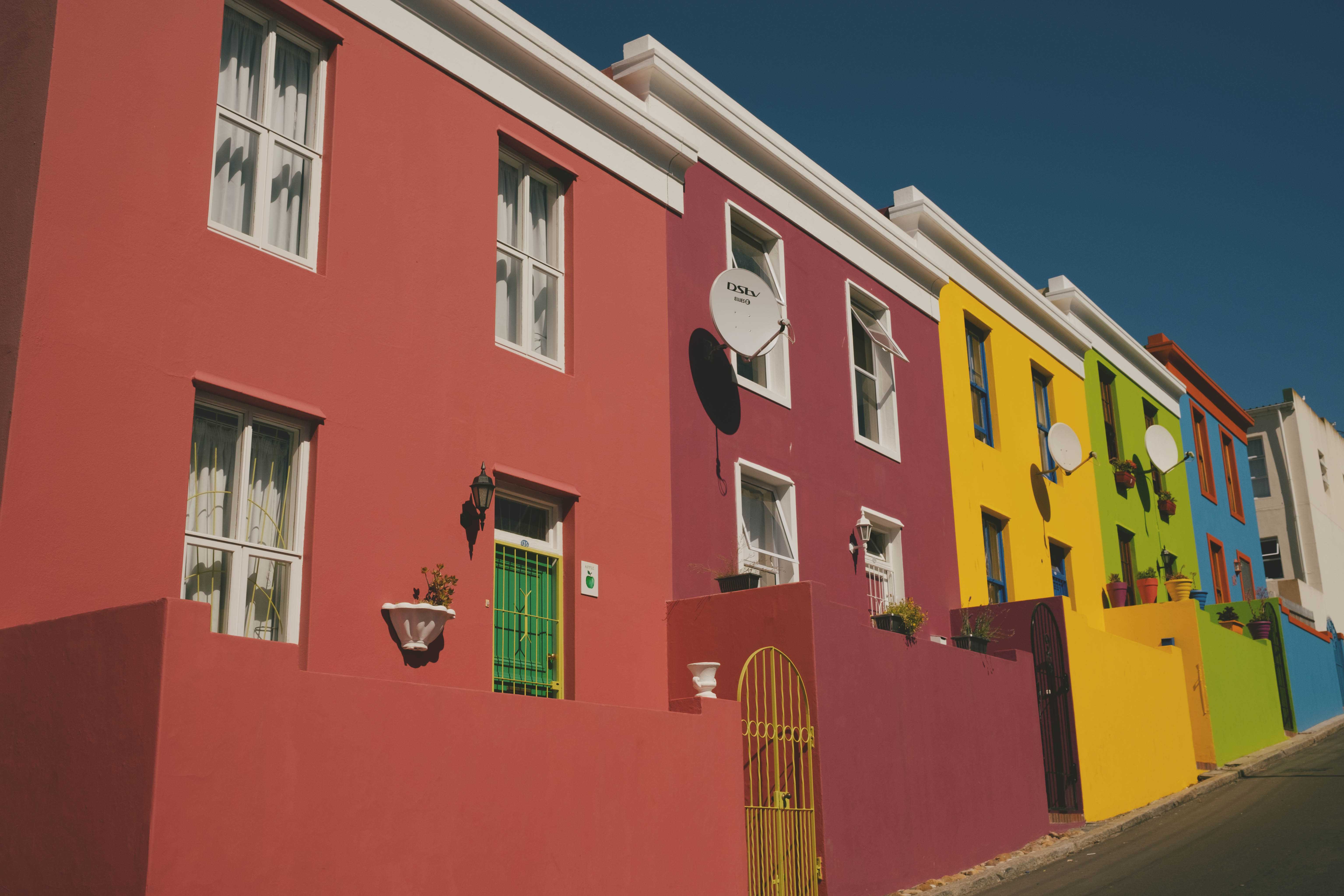 Row of brightly-colored houses along a hilly street