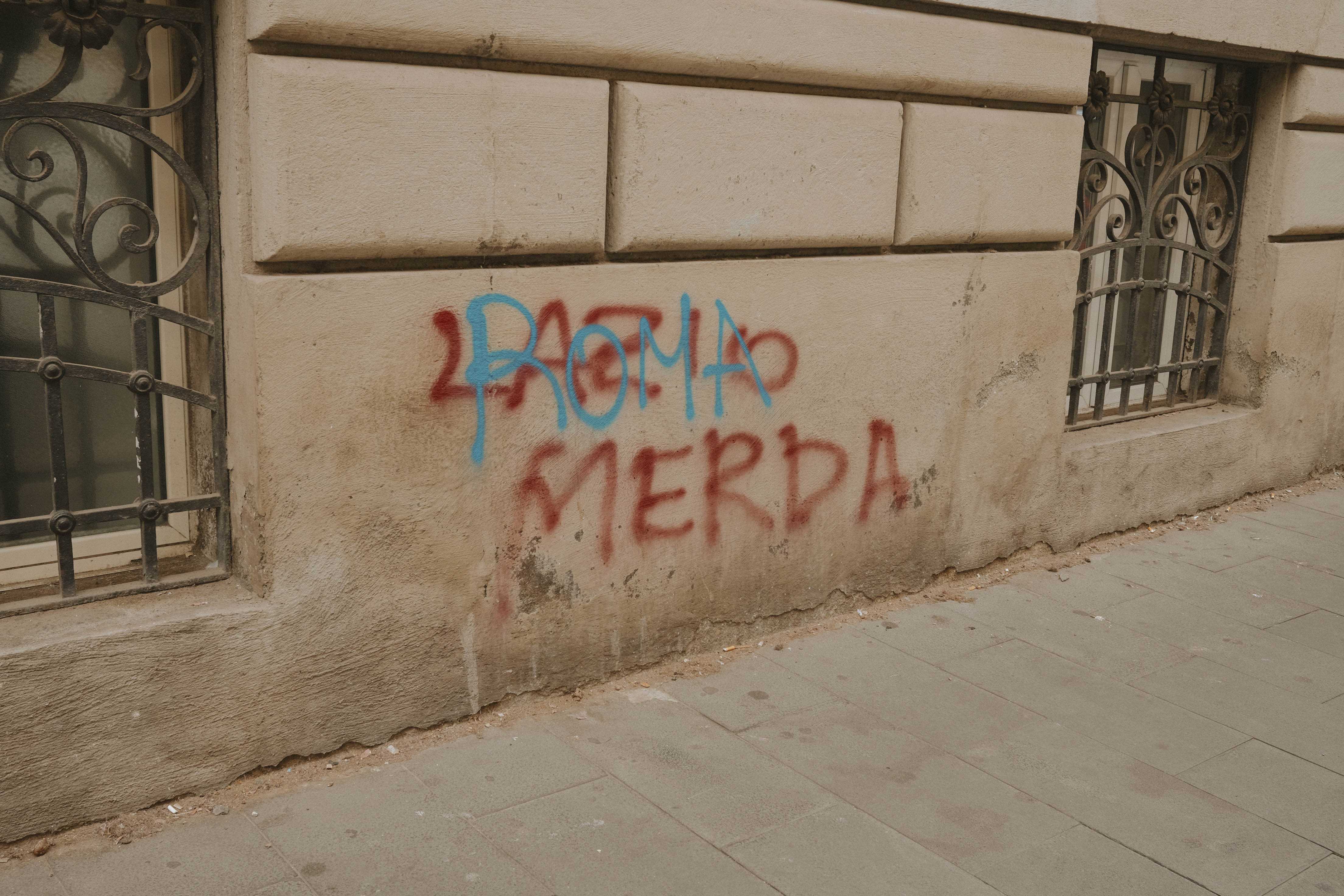 Graffiti reading Lazio merda, then someone wrote Roma over that