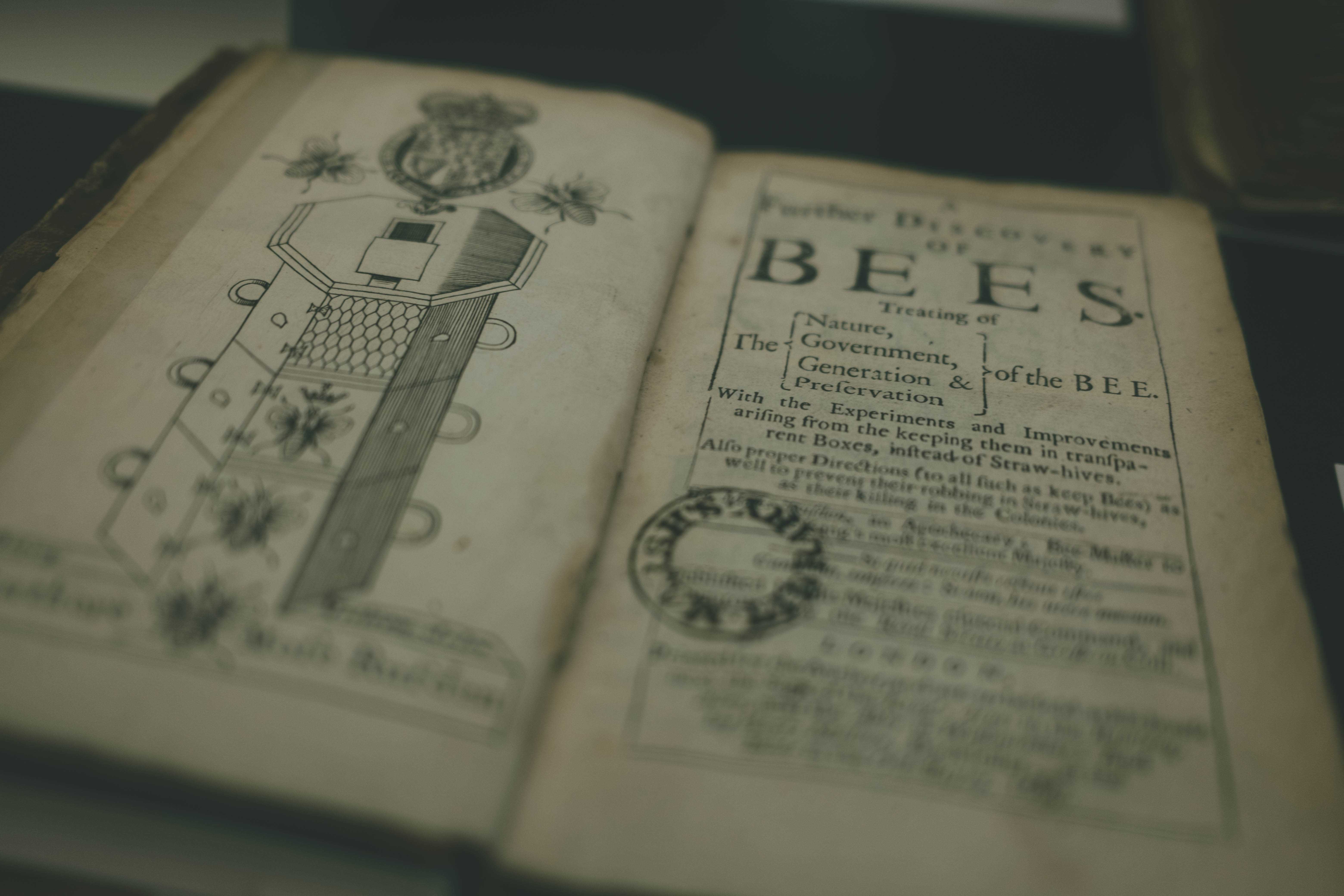 An old book about bees opened to a depiction of a beehive
