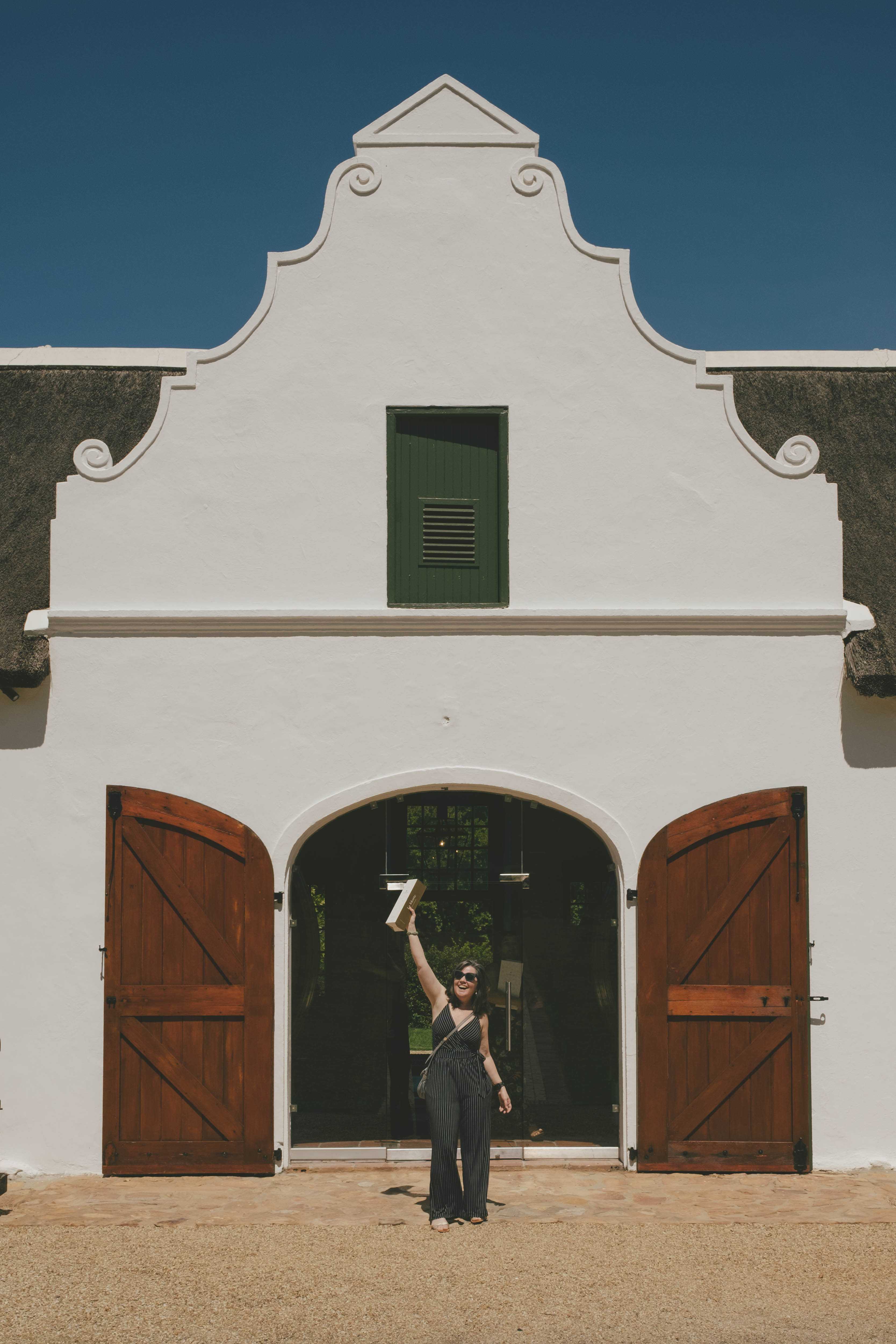 Mirna, holding up a bottle of wine that was purchased at La Motte, looking victorious