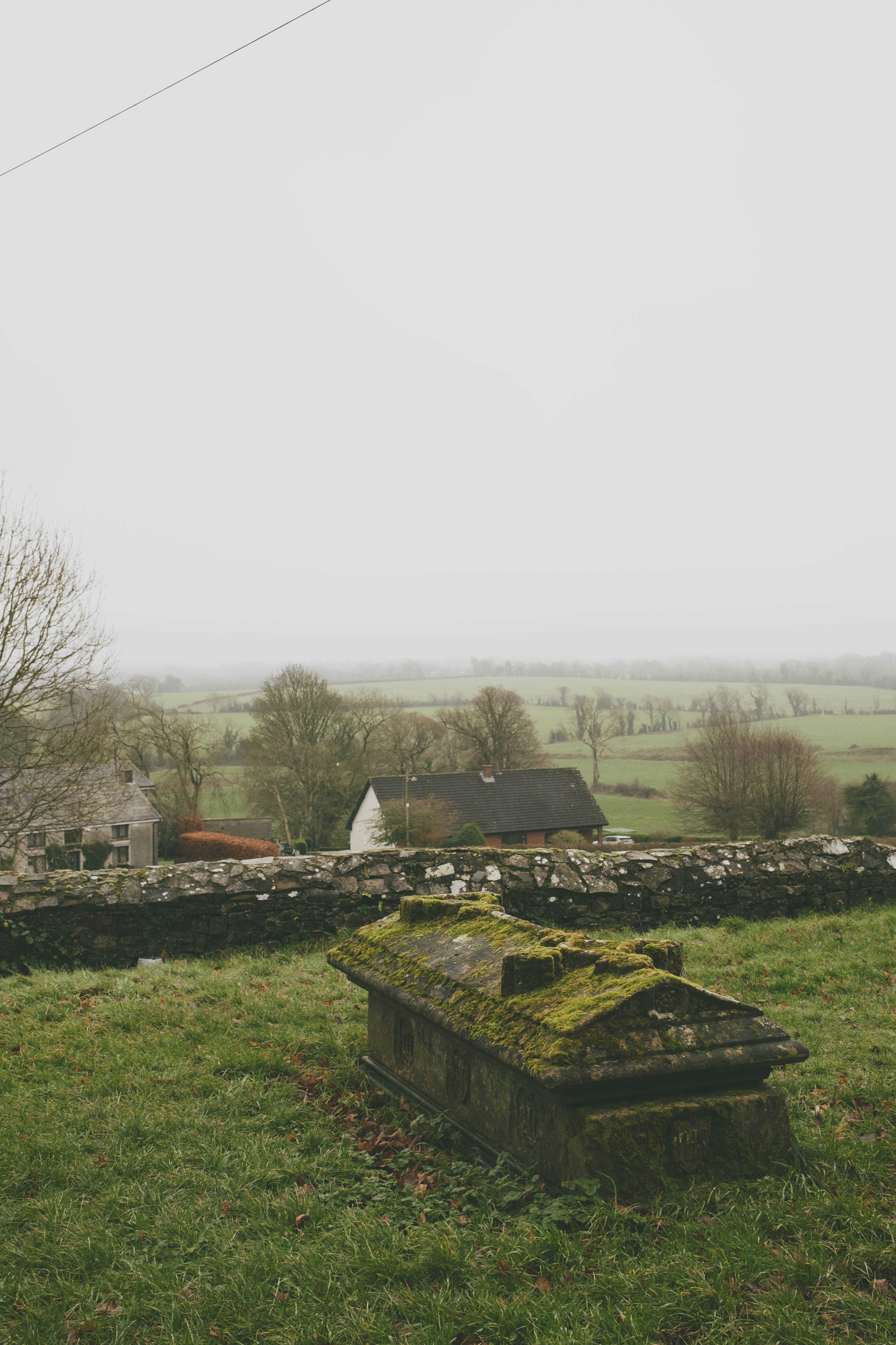 Tomb overlooking a field on a foggy day