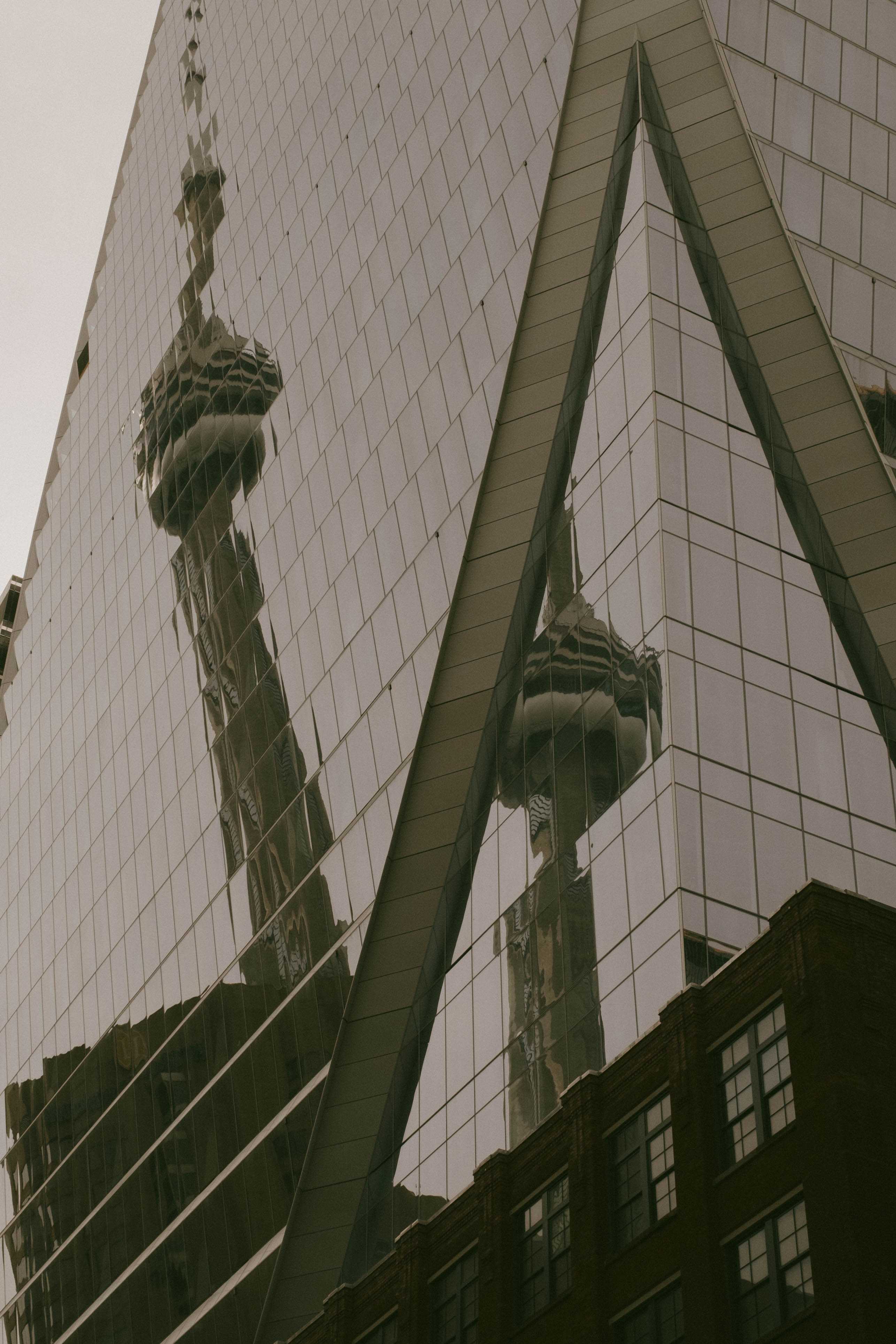 CN Tower reflected in the glass of another skyscraper