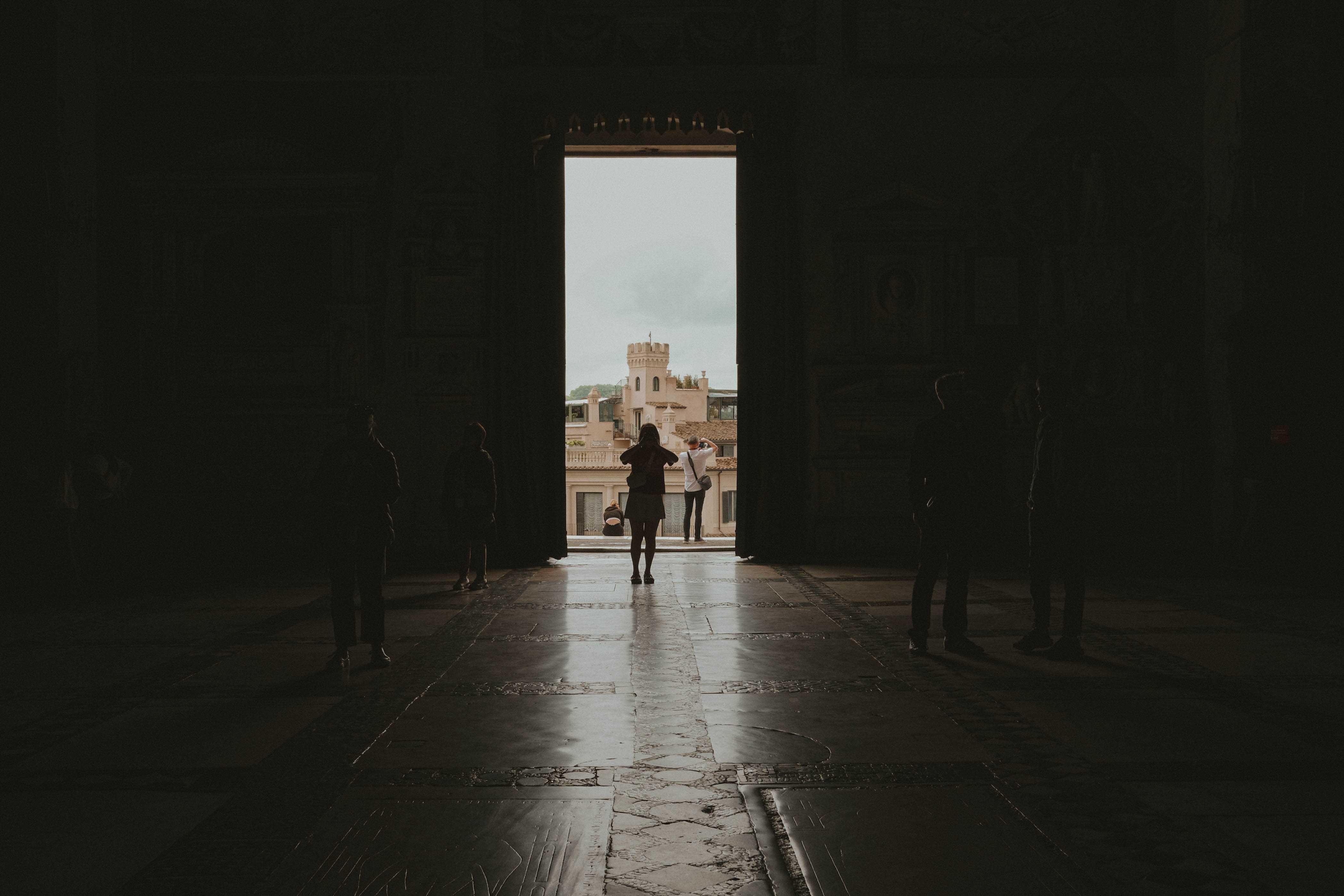 Silhouette of someone taking a photo inside a dark church