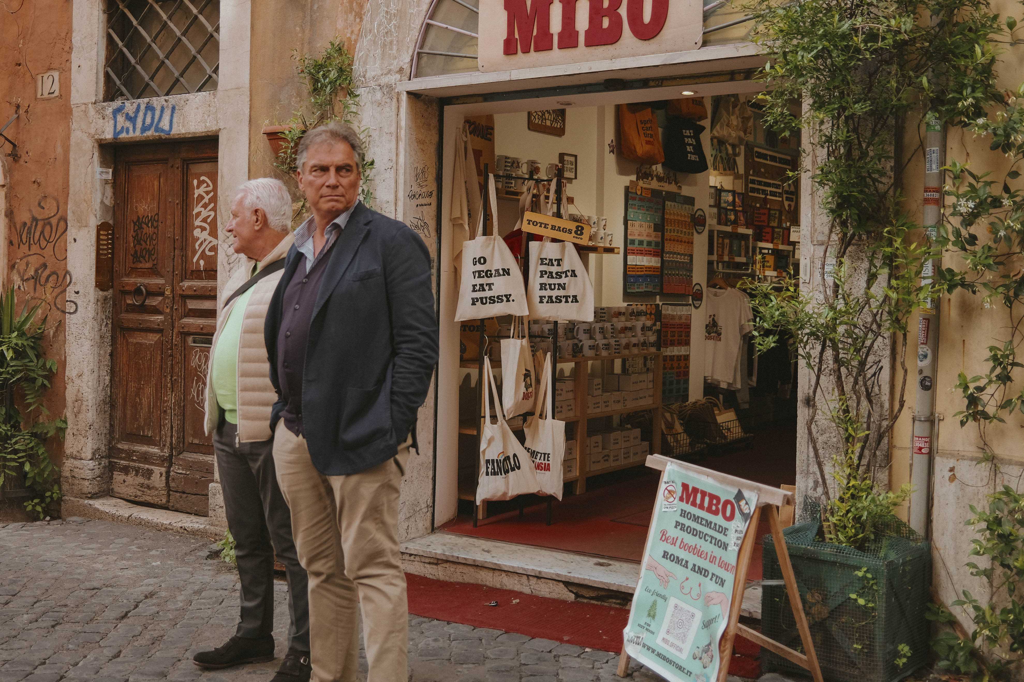 Two older men standing in front a tourist shop