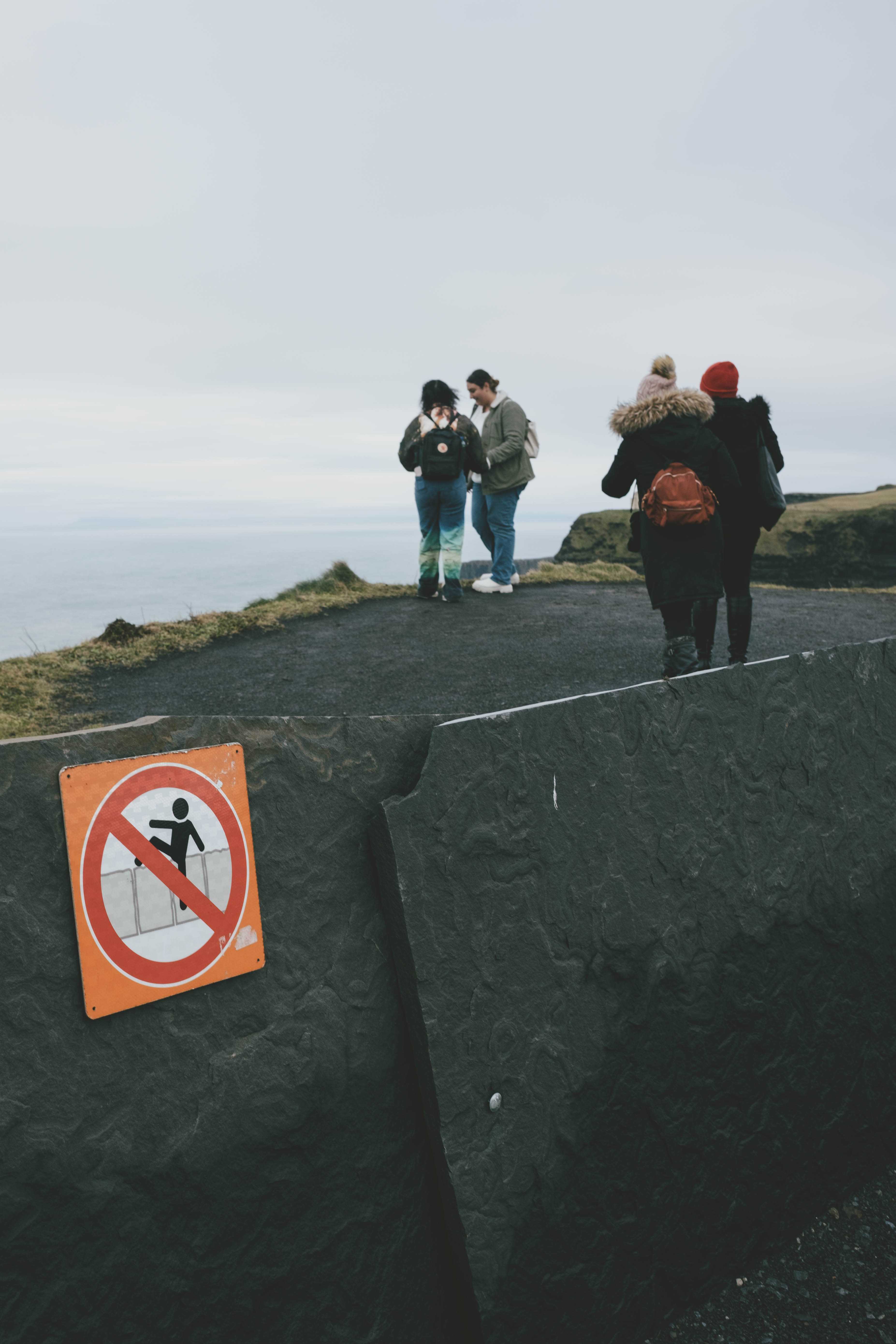 Sign telling people not to hop the fence when people have clearly hopped the fence.