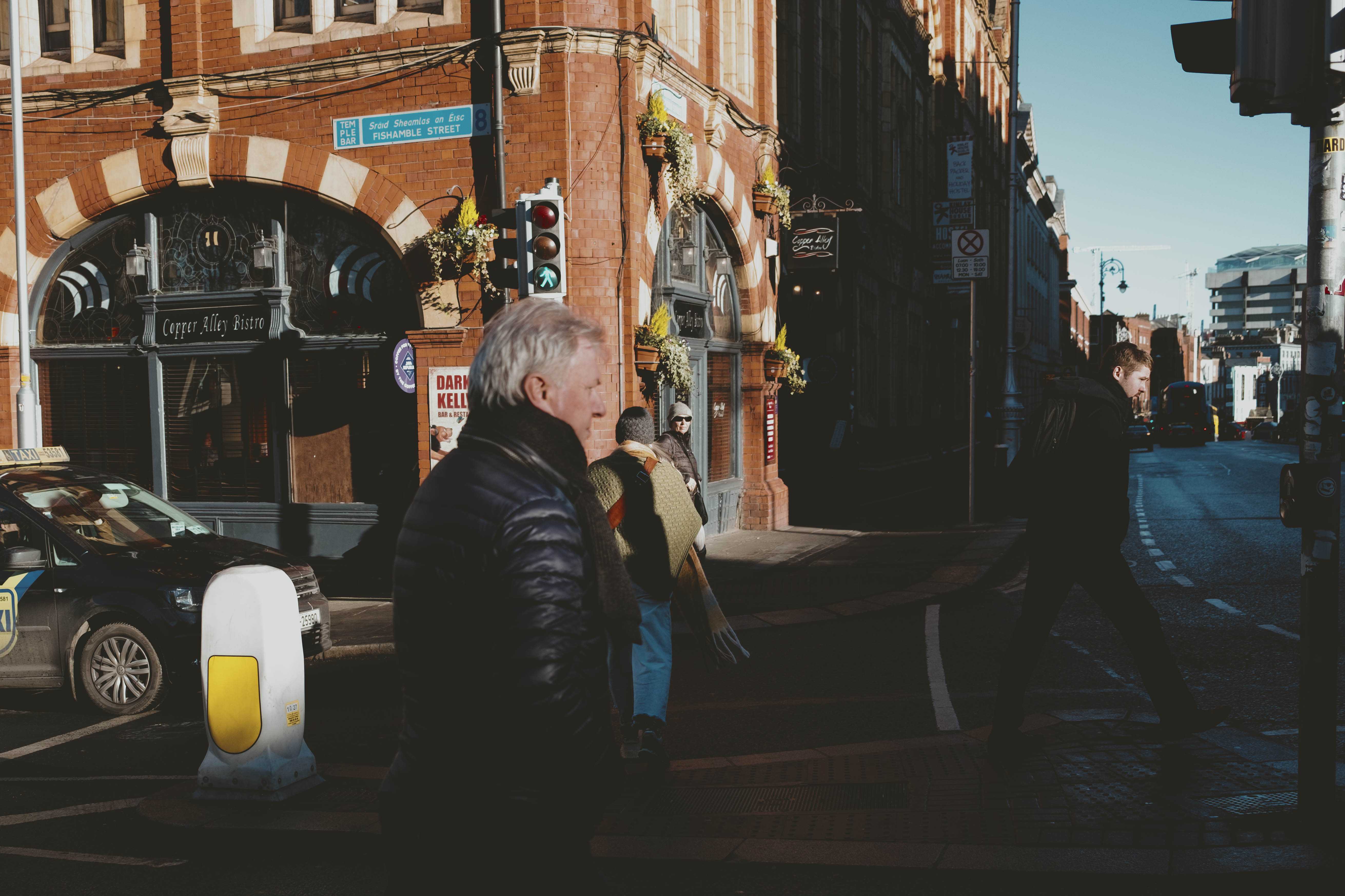 A man crossing a street, seemingly in a hurry.