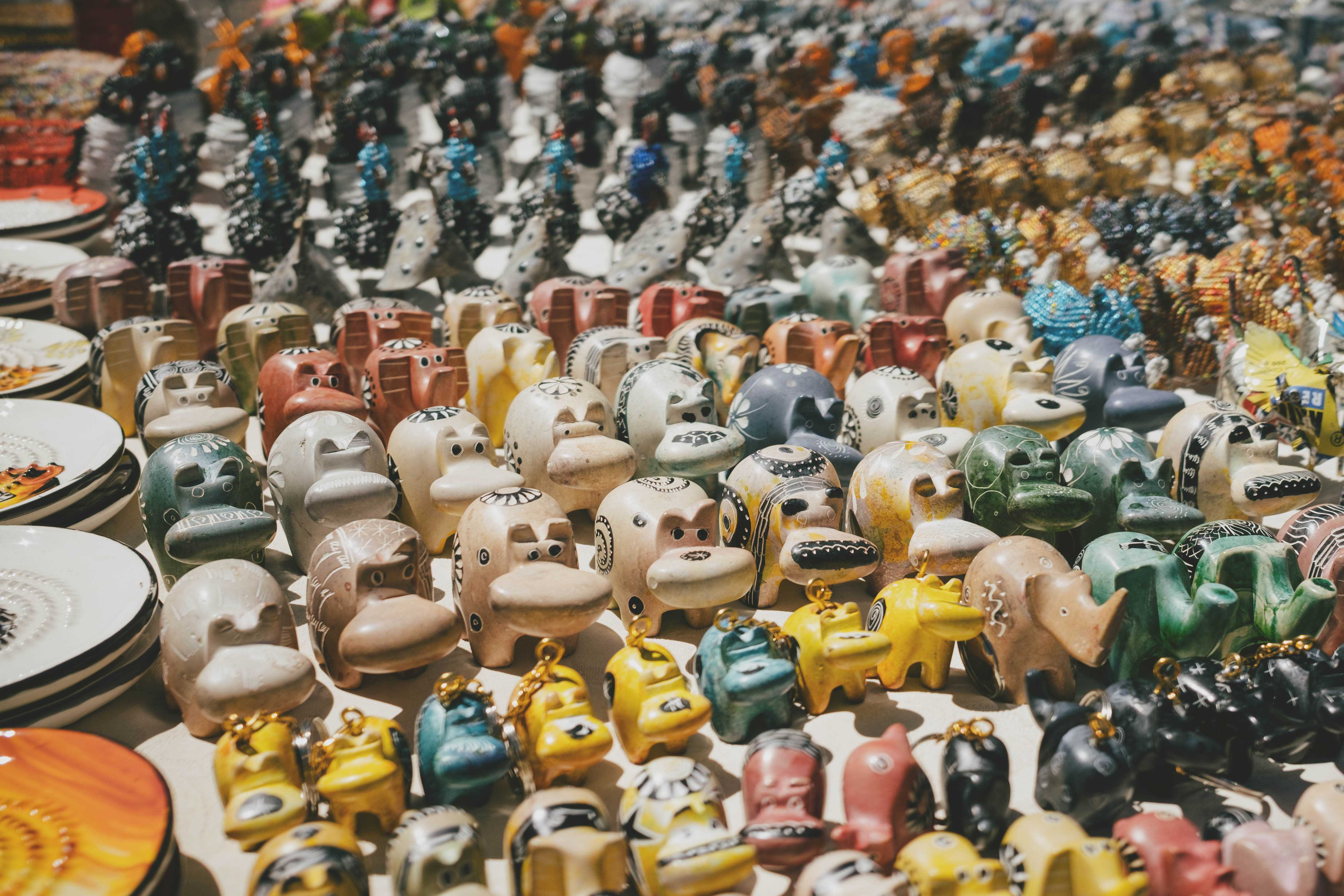 Rows of dozens of carved wooden animals for sale at a handicraft market