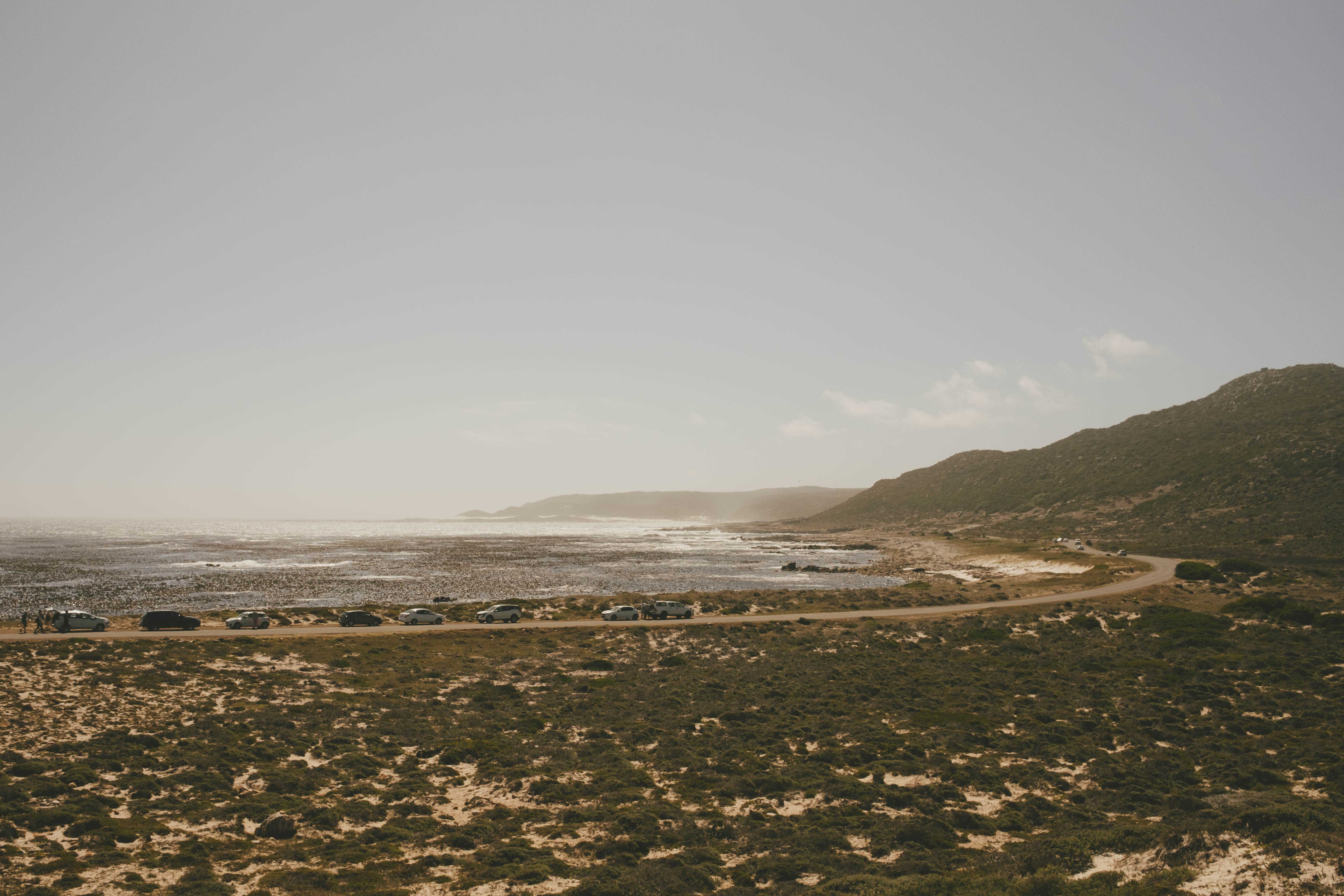 Cars parked on a road that runs along the beach