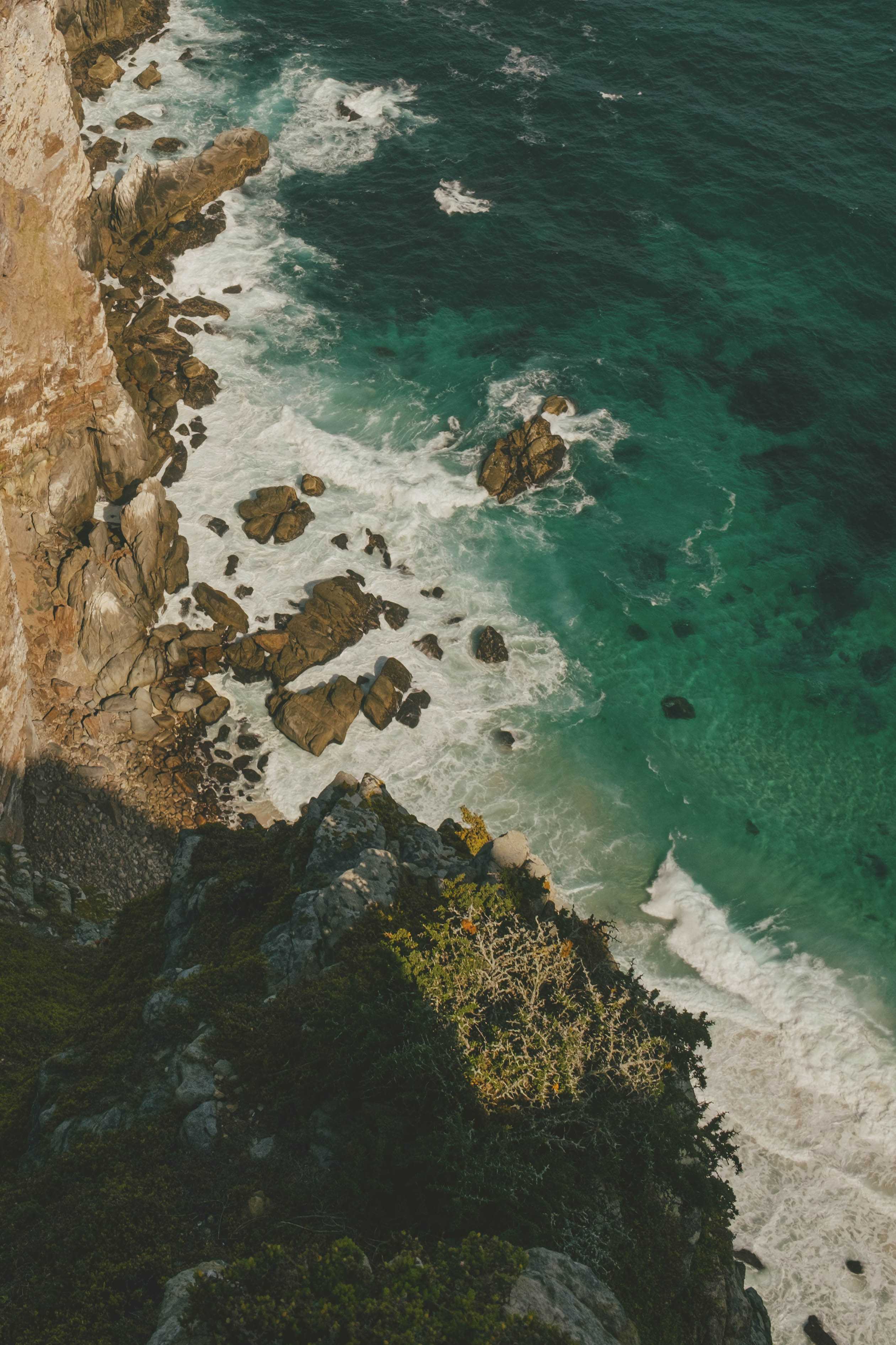 Waves crashing against rocks and the seawall below.