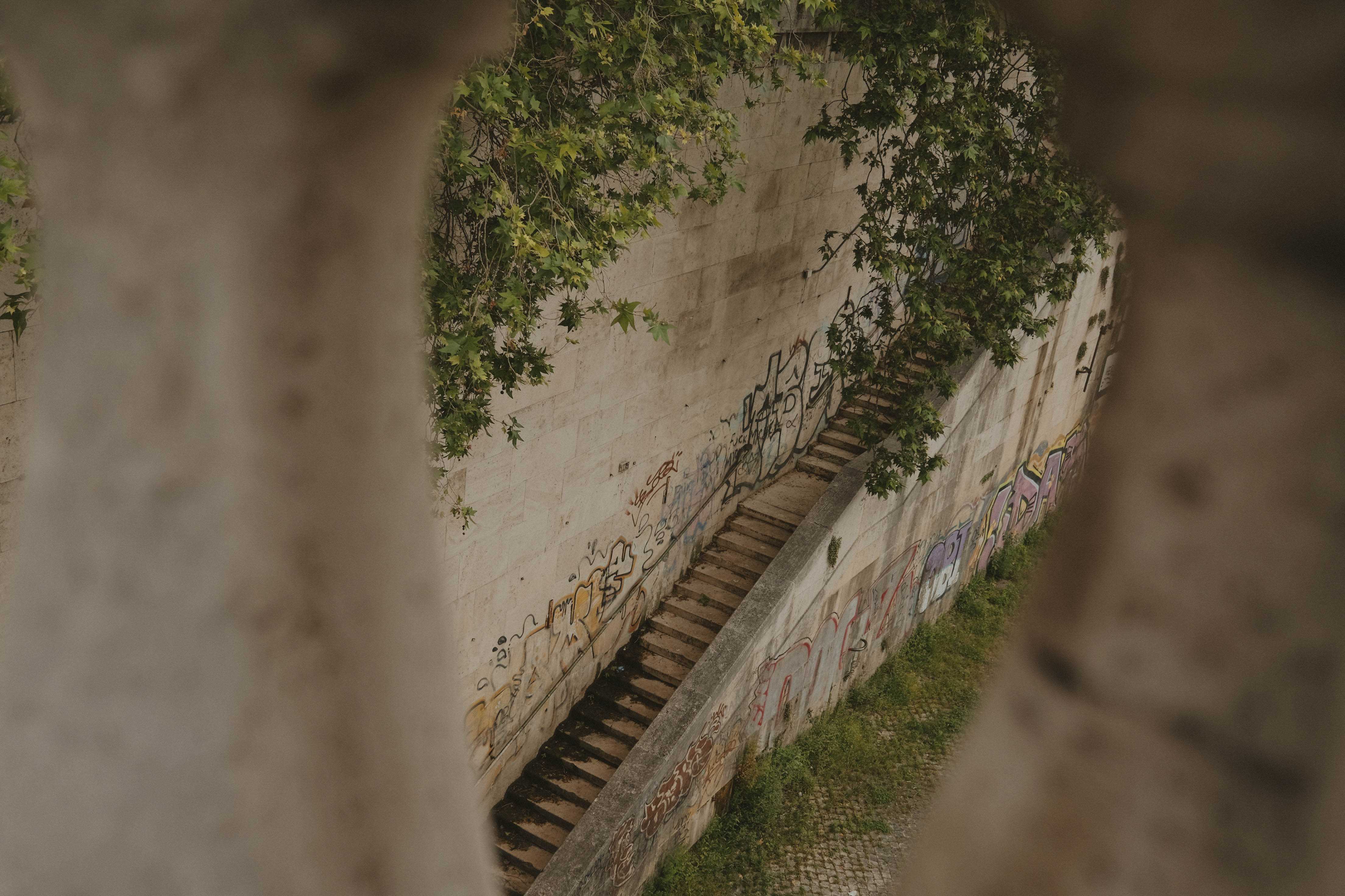 Stairway leading down to a walking path, framed by spindles on a bridge