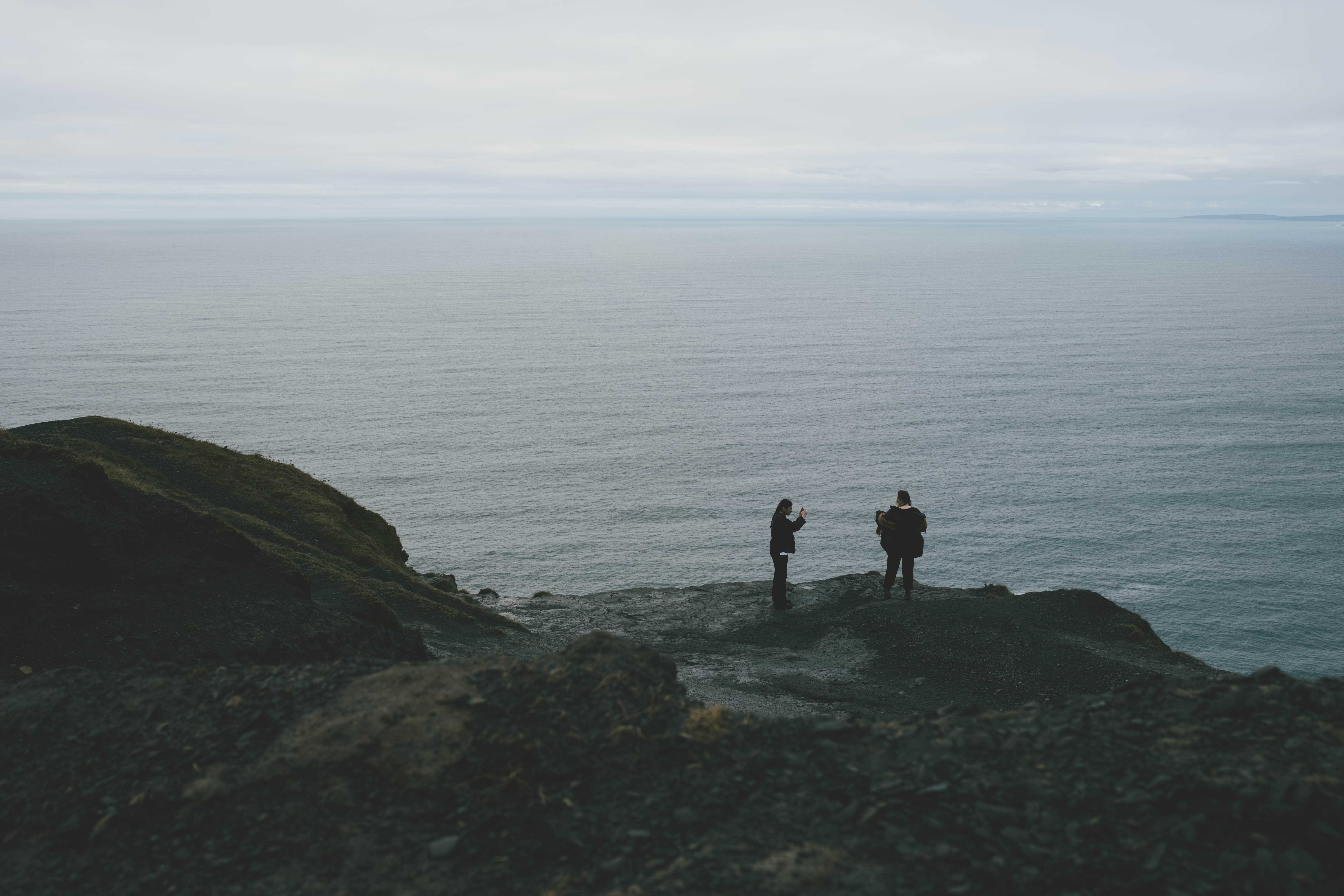 A person posing for a photograph standing at the edge of the cliff